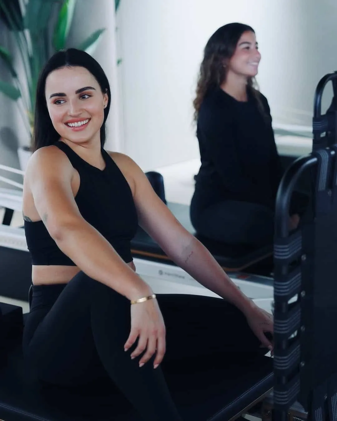 Client smiling during a Reformer Pilates class at The Reformr