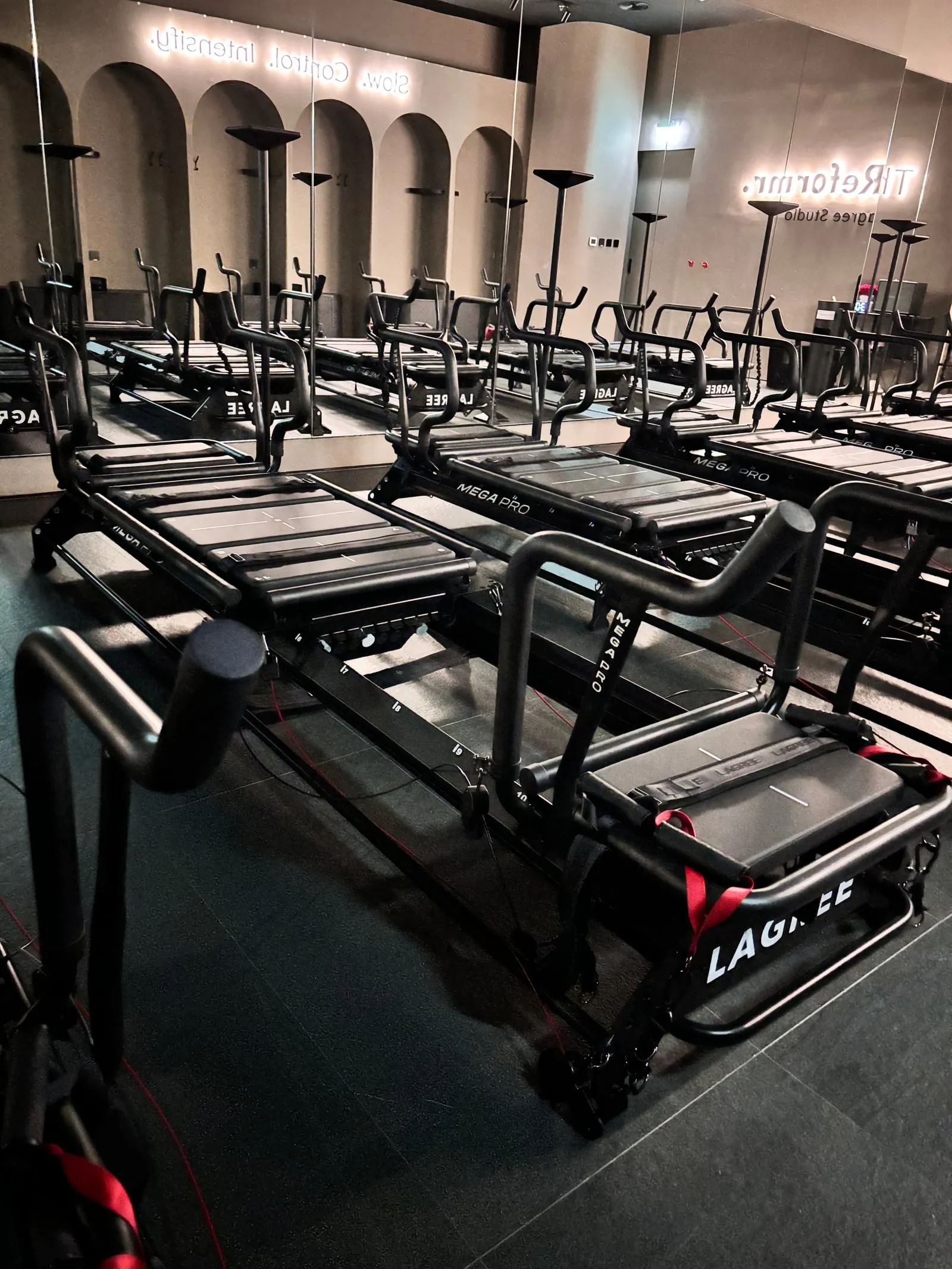 Rows of black Lagree Megaformers beneath the arches at The Reformr Lagree Studio, Abu Dhabi Mall