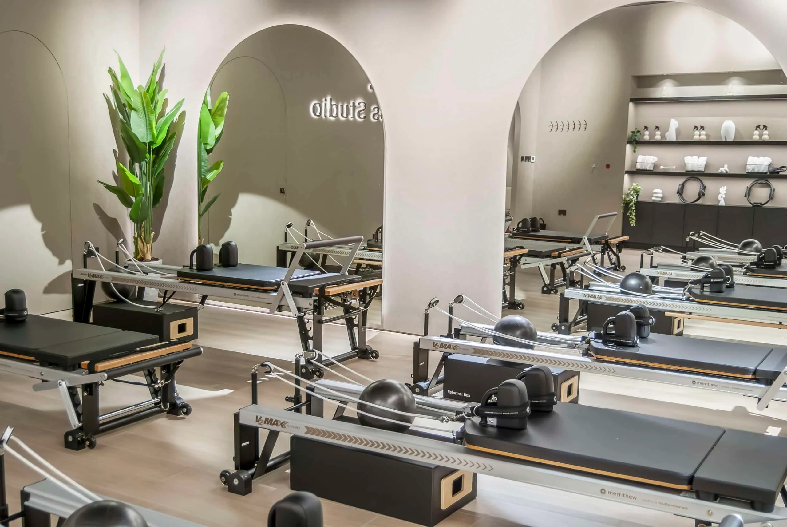 Bright white arches, plants and Merrithew reformers at The Reformr Pilates Studio, Shams Boutik